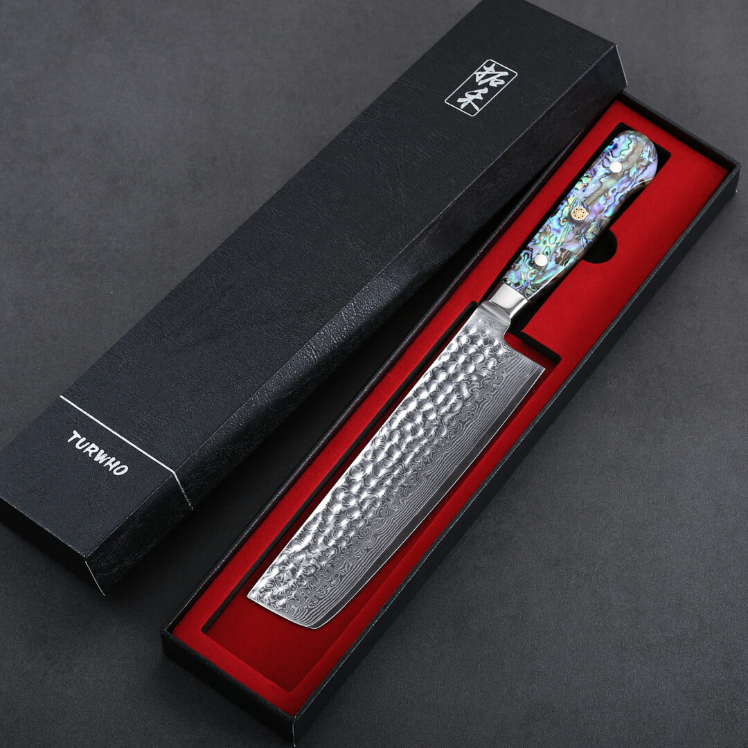Japanese Style Chef Knife with Paua Abalone Handle If you are looking for a perfectly balanced knife that lets you slice food quickly, then this is the knife for you. Material: Forged from VG-10 stainless steel clad, this knife is designed to be durable. Forged using 32-layers of high carbon stainless steel with a Damascus look, this knife is made for speed cutting. The knife is delicate and very light to the touch. Special Features: The knife is off-set to one side which can be the perfect knife for right-handed cooks. The knife is very thin to suit different slicing techniques. This is a knife that might need some getting used to. Since most Nakiri knives are centered, handling the knife is easier, in the case of the Shun Nakiri knife, the offset makes it quite difficult to adjust since the weight distribution leans on the right (mostly on relying on the pressure from the thumb and the wrist). But when you get used to this knife, it will feel like it is an extension of your arm. The knife’s blade has Granton edges with Damascus layers that add gentle waves and creases on the surface of the blade. These spaces are effective air pockets that allow the food to easily slide off the blade of the knife. In addition to its function, the Damascus layer and the Granton edges add stunning aesthetic value to the knife. Handle: Shun knives are known to have their handles made from Pakkawood. Pakkawood is a premium wood with beautiful rings that add a nice touch to the knife. It offers great grip even in wet conditions. This knife has an ergonomic D-shaped handle. It is a little narrow but is well-balanced especially for those with small hands.