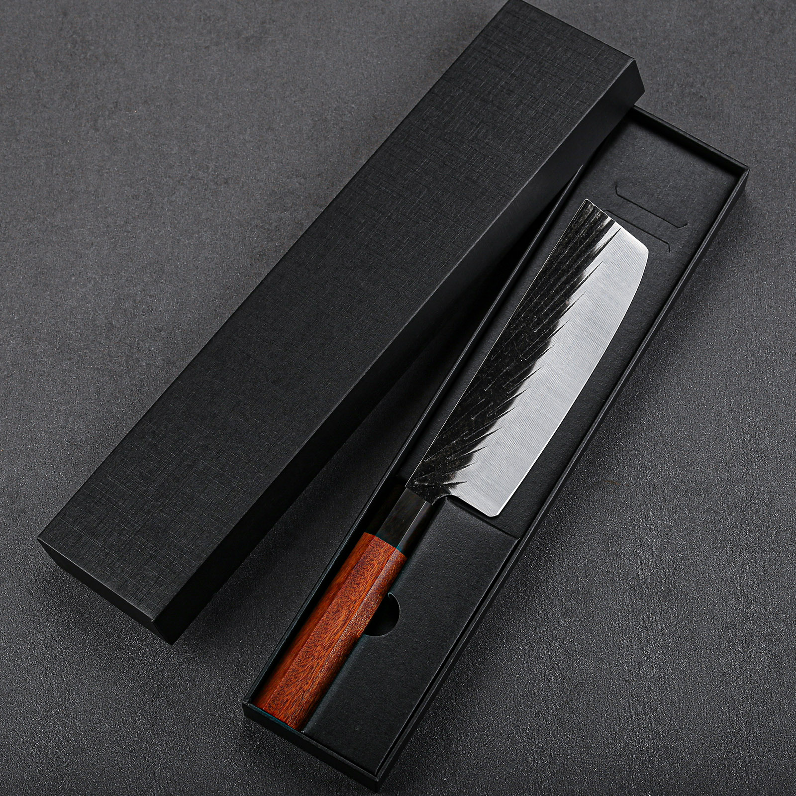 The perfect mix of traditional Japanese design and state-of-the-art tech, this 7-inch cleaver nakiri knife is both pretty and practical. It features a traditional tsuchime (hammered) finish that prevents food from sticking to the blade and reduces the knife drag while in use. The blade is made from high-carbon German stainless steel and comes with a Rockwell Hardness Scale of 57, which means it should hold up to a lifetime of daily use. The knife weighs a svelte 8.8 oz and can be effortlessly maneuvered through fruit and vegetables. Designed with a classic black handle, it will fit into any kitchen.