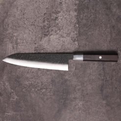 AUS-10 gyuto chef knife full profile on stone with kurouchi blade and ebony handle