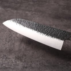 Kurouchi textured finish meeting the polished bevel on the santoku blade