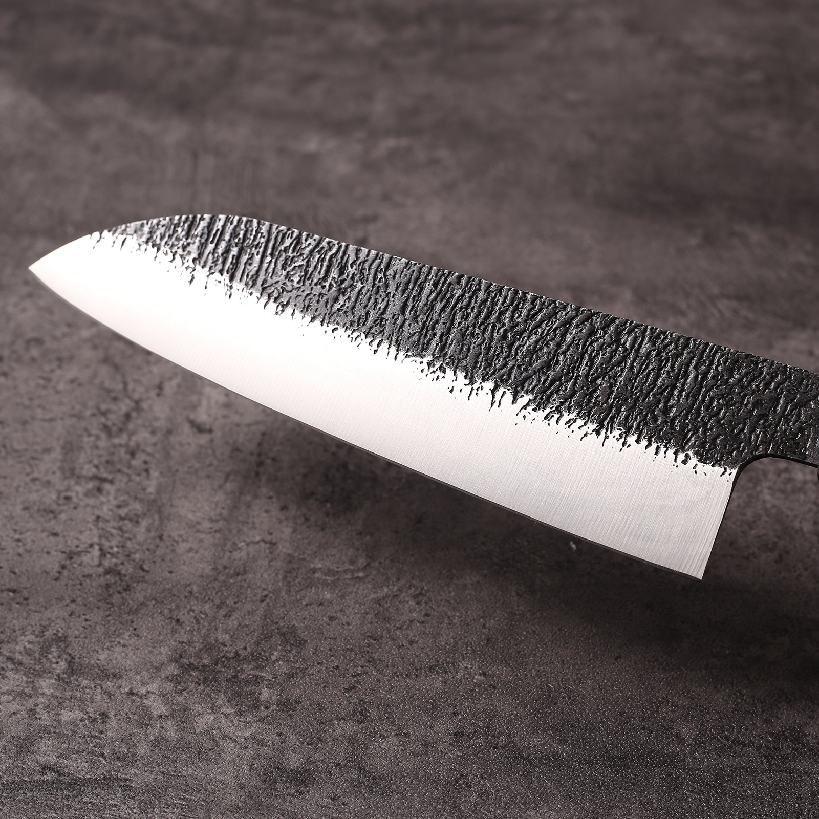 Kurouchi textured finish meeting the polished bevel on the santoku blade