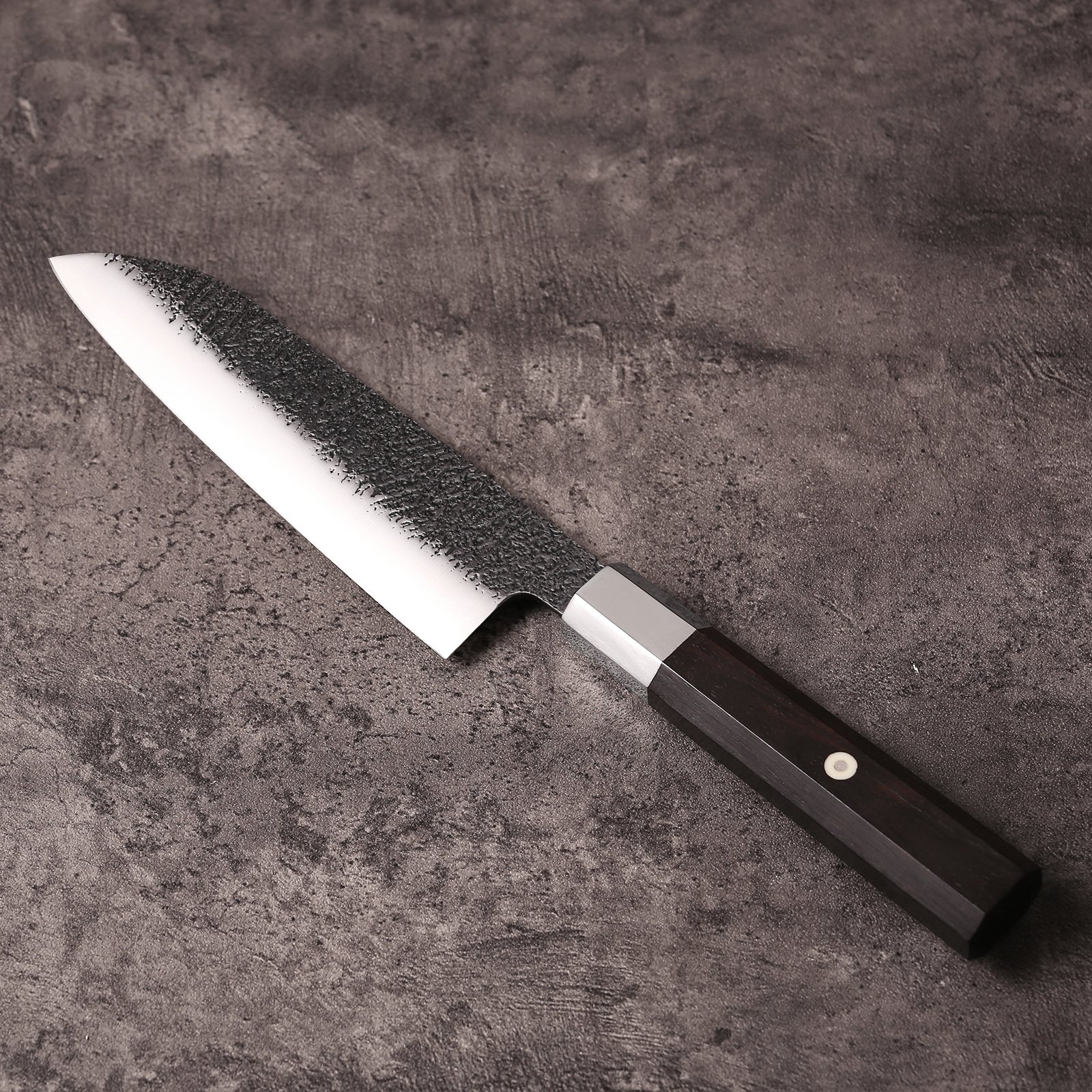 Reverse side of the santoku blade with textured kurouchi upper and polished bevel